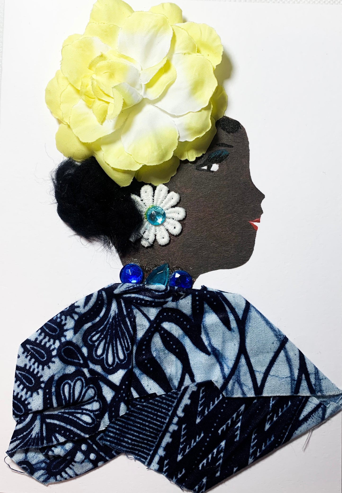 This card was given the name Blooming Brunswick. This woman is wearing a blue bloude with a light blue background and a dark blue floral overlay. Her necklace is three blue gems, and she wears a white flower earring with a blue gem in the middle. In her short black hair, she wears a flourishing large yellow flower. 