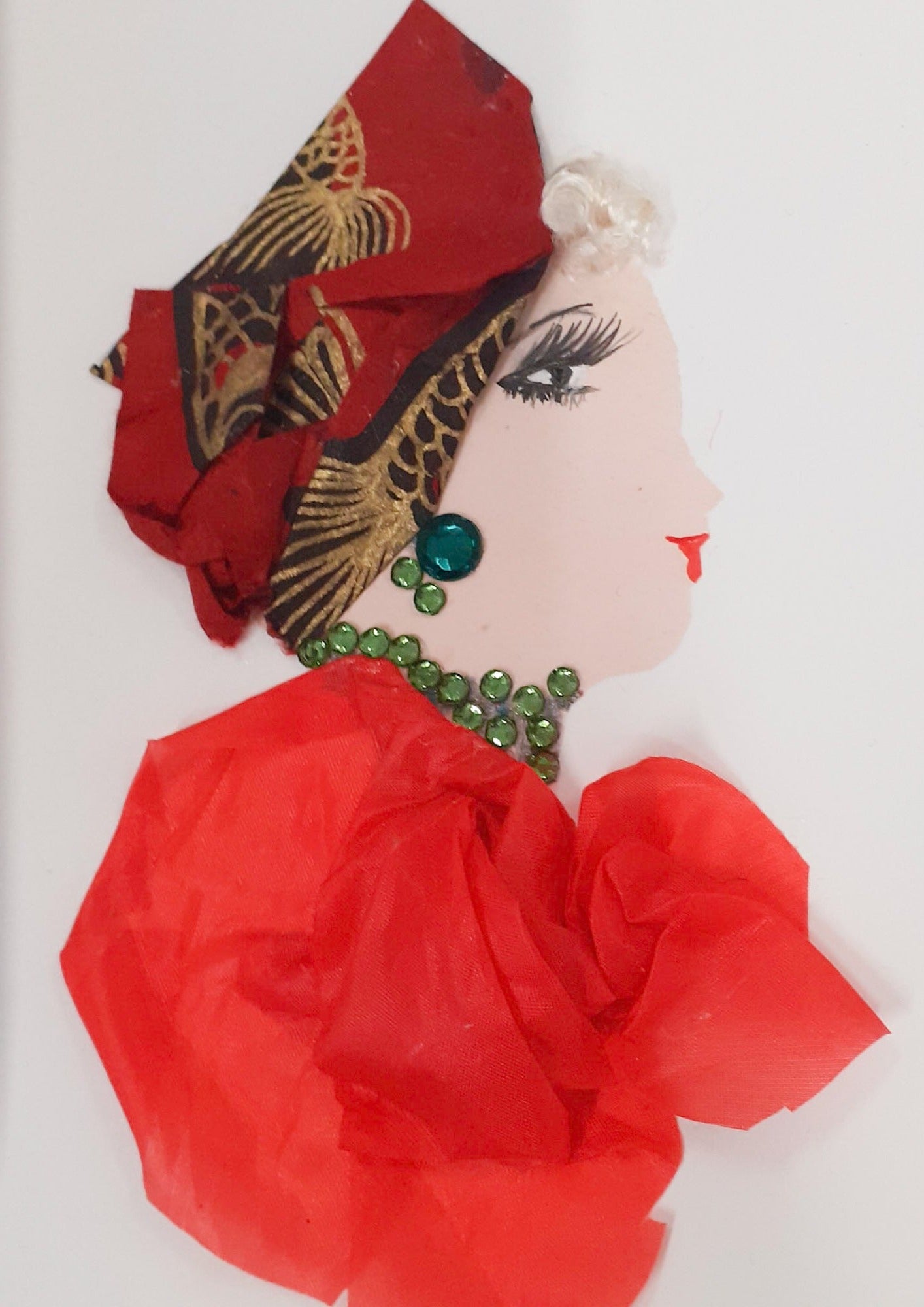 This card was given the name Chelsea Charelene. Chelsea wears a red chiffon dress, a green gem necklace, green earrings, and a red headscrd with a gold koi fish pattern over her platinum blonde curly hair.