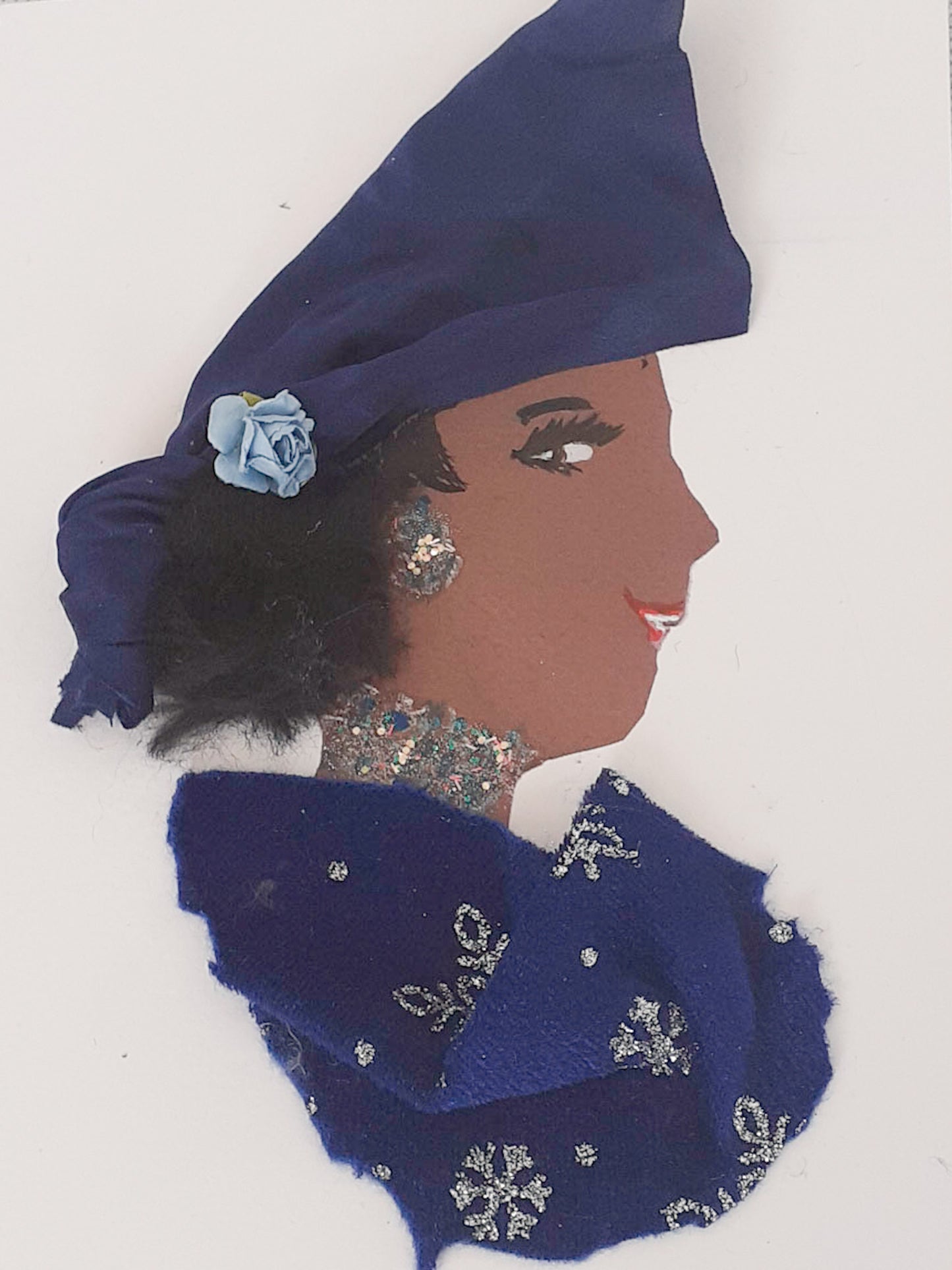 This card depicts a woman wearing a blue dress with a silver glitter snowflake pattern. She wears a matching blue headscarf with a small rose on it.