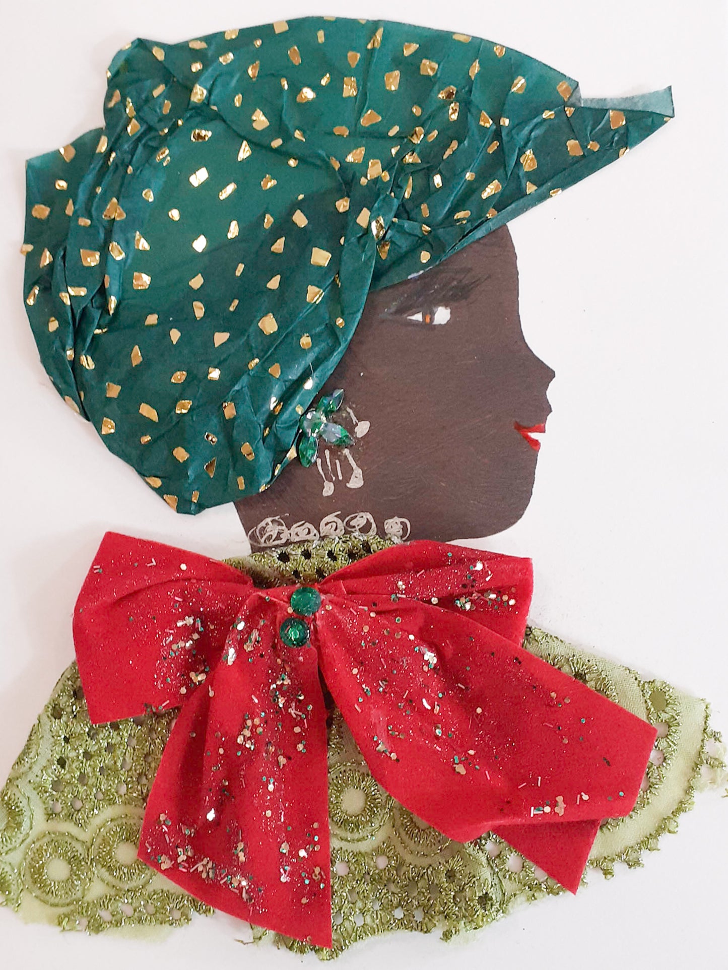 This card is named Cherry Christmas. She wears a green eyelet fabric dress with a large red bow covered in silver sparkles on top. Her headscarf is dark green and has a gold fleck pattern to it. 
