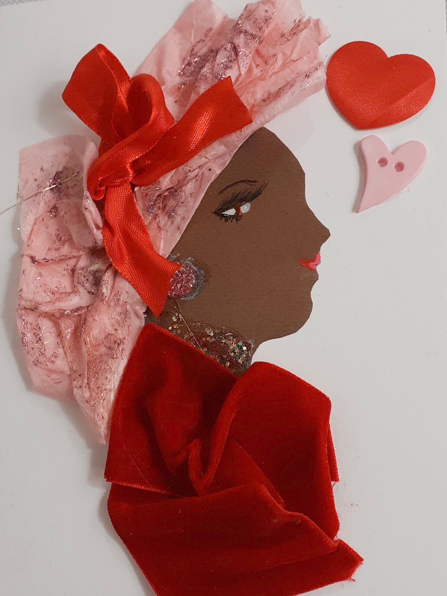 This card is given the name Love. Love wears a red velvet blouse and a light pink tissue paper headdress with a satin bow on it. In the top right corner, there is one red heart and one pink heart. 
