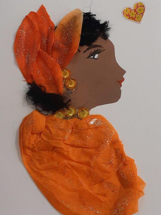 Orange Orlando is wearing an orange blouse with orange sapphire necklaces and a lovely flowery headgear on her soft black hair. She looks absolutely stunning with her beautiful makeup, giving it a glowing and radiant finish.
