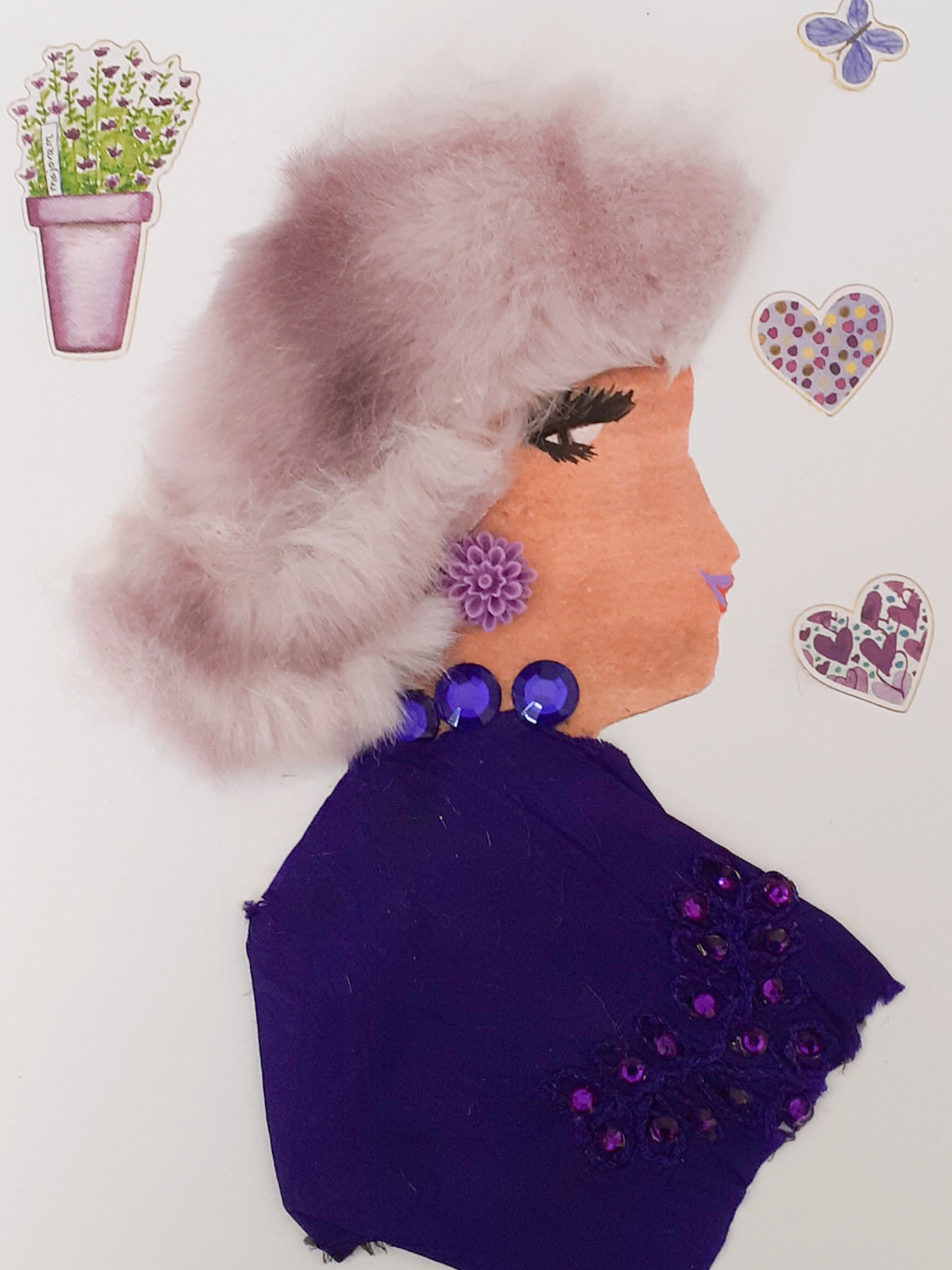 This card is called Camila. She wears a light purple fur headpiece, a dark purple blouse, and a purple gem necklace. TO her right there is a small butterfly sticker and two heart stickers. To her left, there is a sticker of a potted plant.