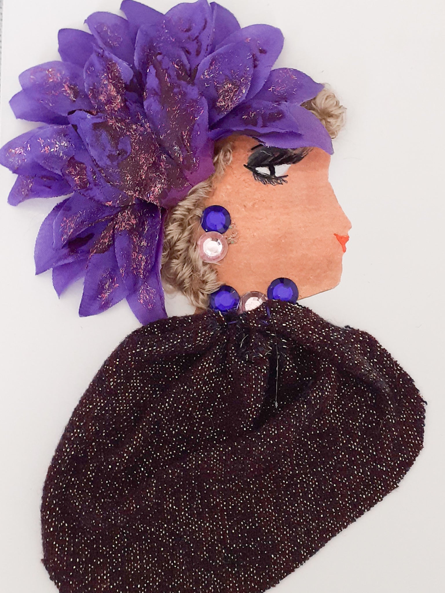 This card is called Valentina. She wears a purple sparkly blouse and a large purple flower in her blonde curly hair. 