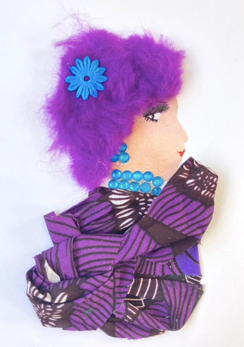 Violet wears a purple and black patterned blouse. IN her furry purple hair, she wears a bright blue flower. Her jewellery is blue gems. 