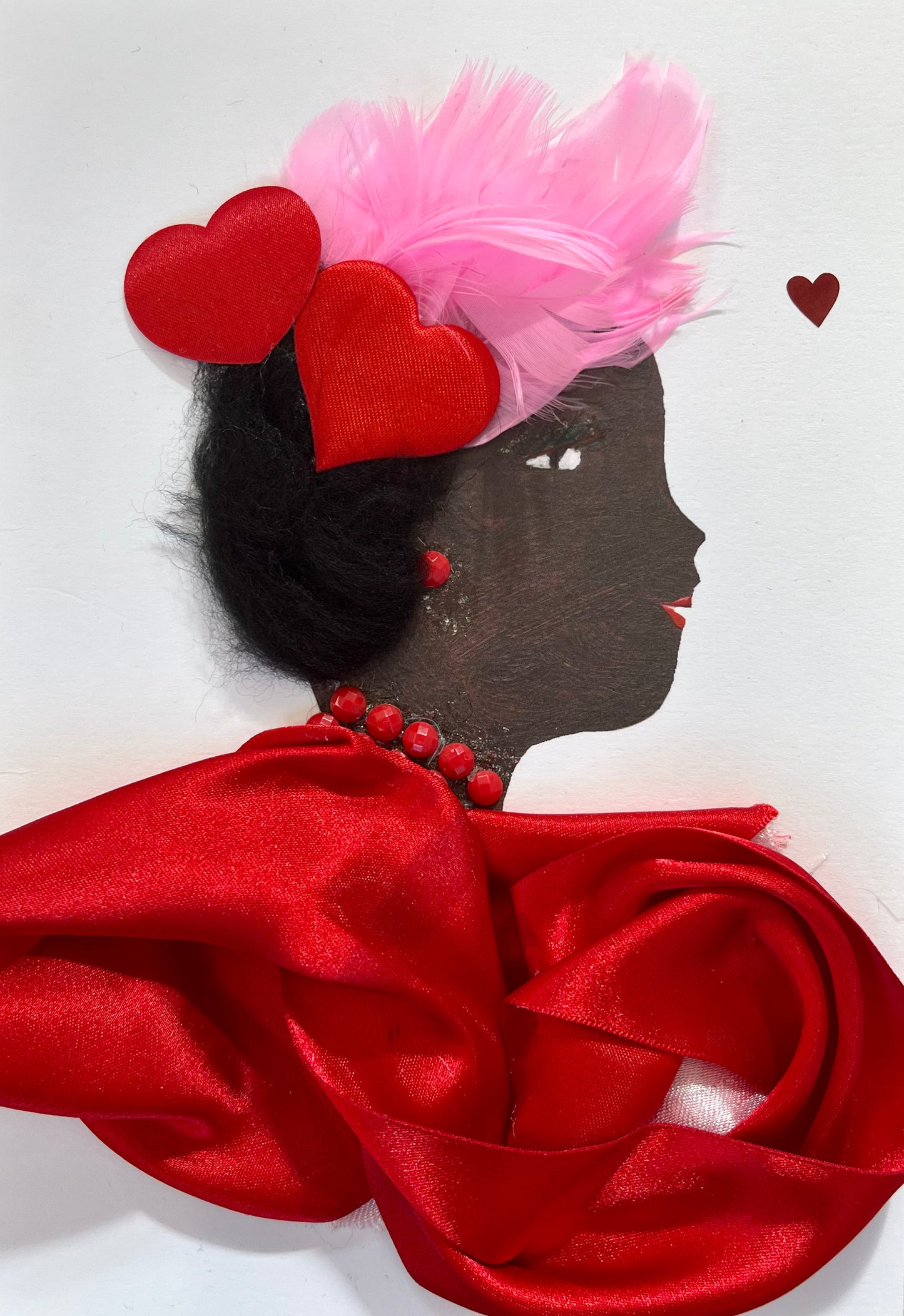 Agnes weras a red silk dress, red hearts and pink feathers in her black hair, and red earrings