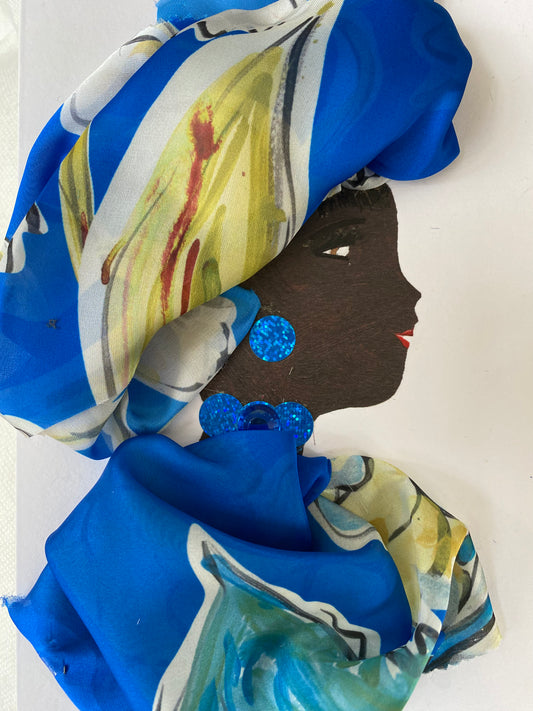 I designed this card of a woman named Betsey Blue. She has a black skin tone and is wearing a ravishing blue pattern head wrap. She wears a matching blue pattern blouse. She wears sparkly blue jewellery.