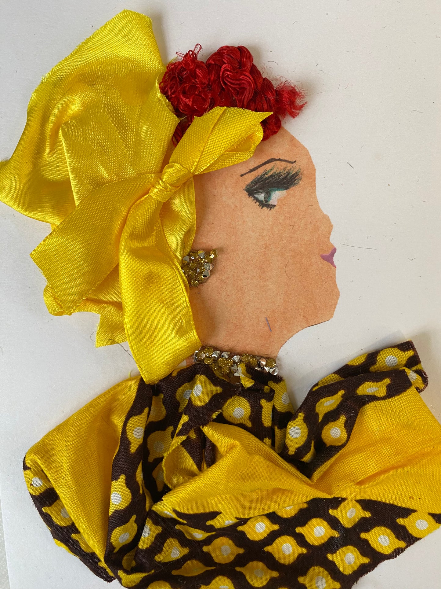 I designed this handmade card of a woman named Sunny Sydney. She has a white skin tone and is wearing a silky vibrant yellow hat that has a tie on the side. She wears a beautiful yellow and black pattern blouse. She wears dazzling yellow and silver jewellery.