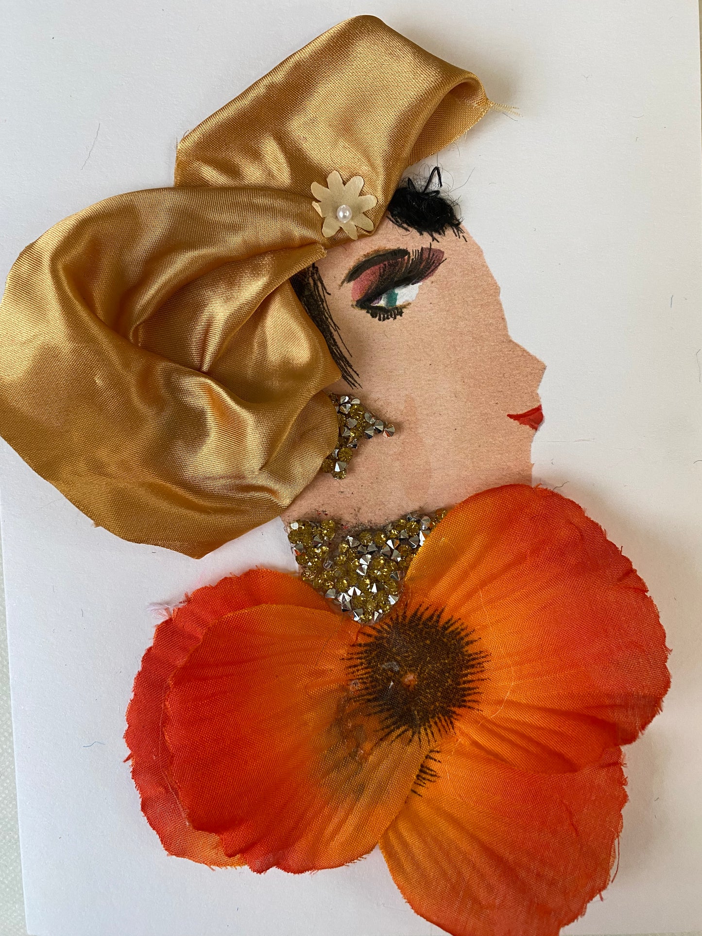 I designed this card of a woman named Tilly Tangerine. She has a white skin tone and wears a silky gold hat. She wears an orange floral blouse with gold and silver jewellery. 