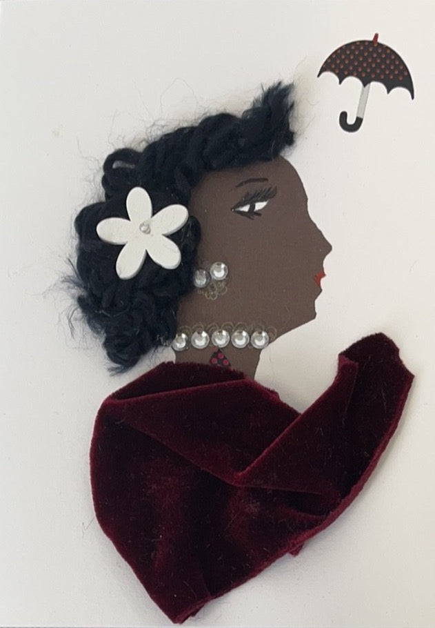 I designed this card of woman who was given the name there shall be showers. The woman has a black skin tone and is wearing a red velvet blouse, a diamanté necklace with matching earrings, and a white flower in her short curly black hair. In the top right corner, there is a small umbrella. 