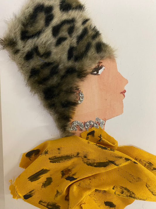 I designed this card of a woman named Carmen Carol. She has a white skin tone and wears an animal print furry hat. She wears a yellow blouse. She wears shiny silver jewellery.