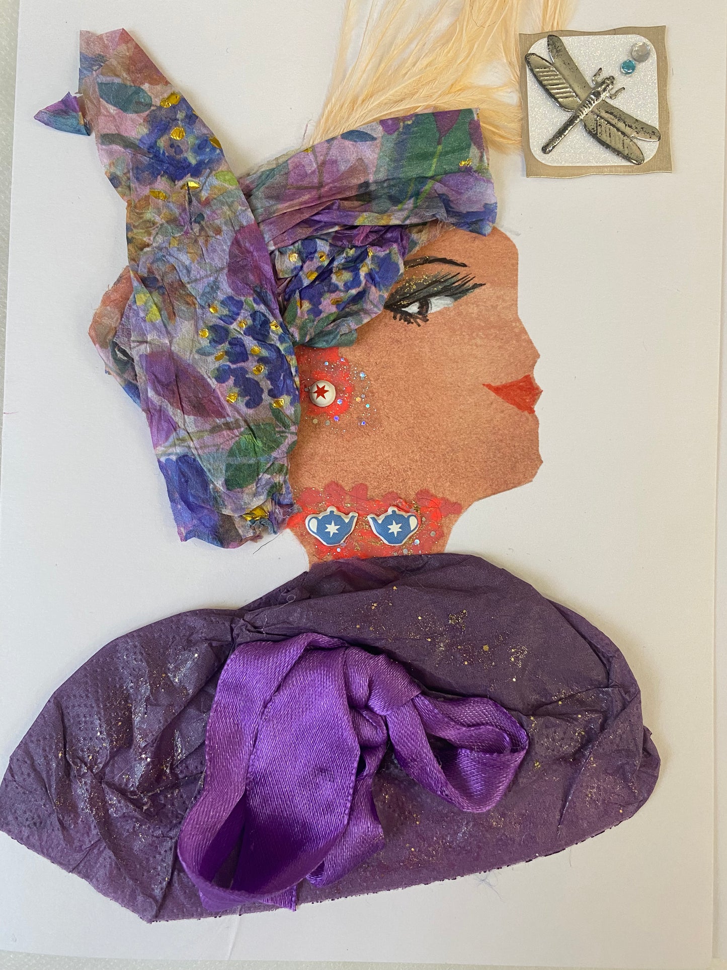 Heather Plum is a unique card featuring a woman with timeless elegance. Her head wrap is printed with intricate detail, while her blouse is a beautiful shade of purple. The finishing touch is provided by the subtle yet eye-catching orange jewellery. A dragon fly symbol adds an extra layer of sophistication.