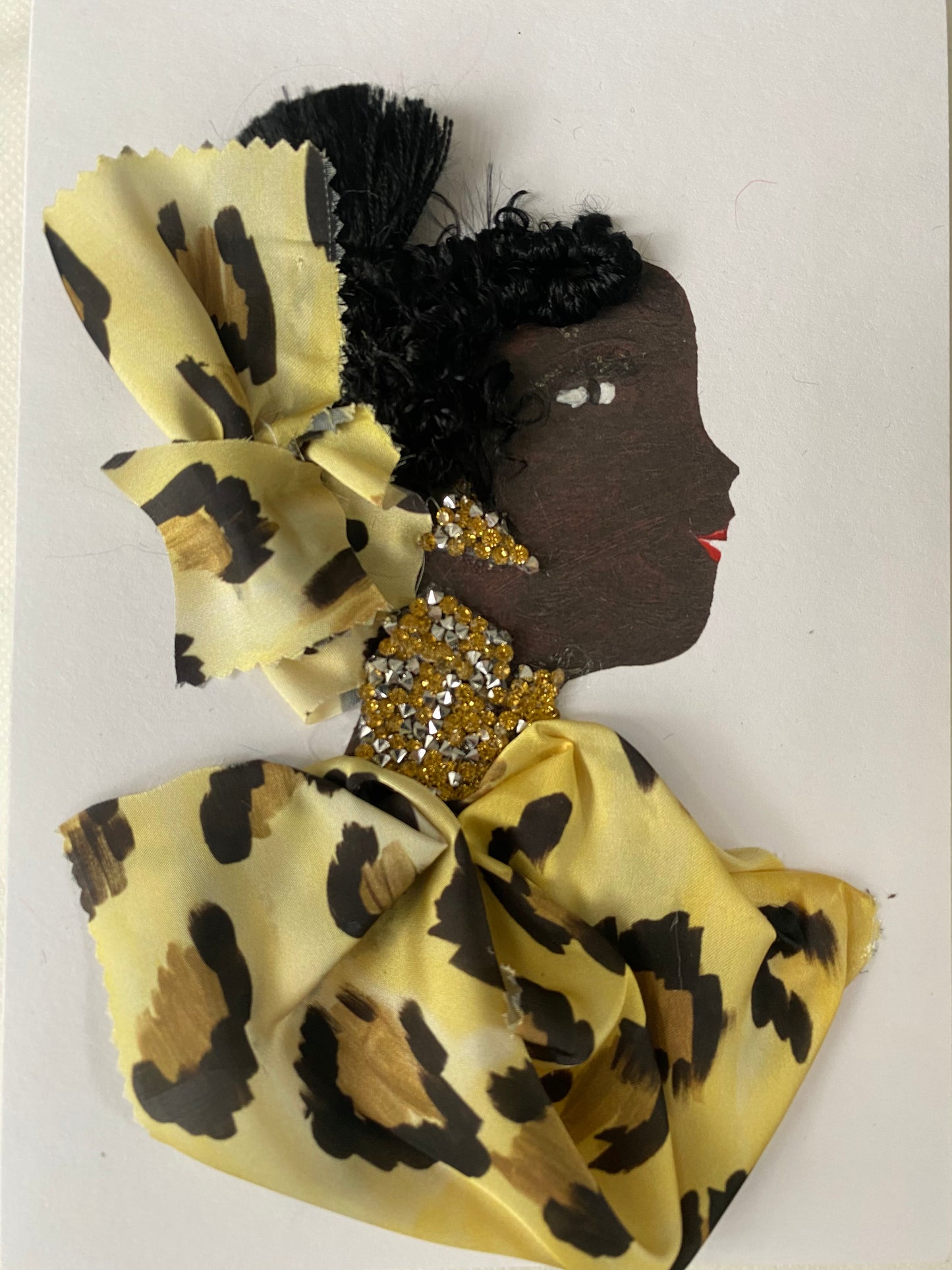 I designed this card of a woman named Dr. Marissa Marylebone. She has a black skin tone and is wearing a yellow animal print hatinator. She wears a matching yellow animal print blouse. She wears stunning yellow and silver jewellery.