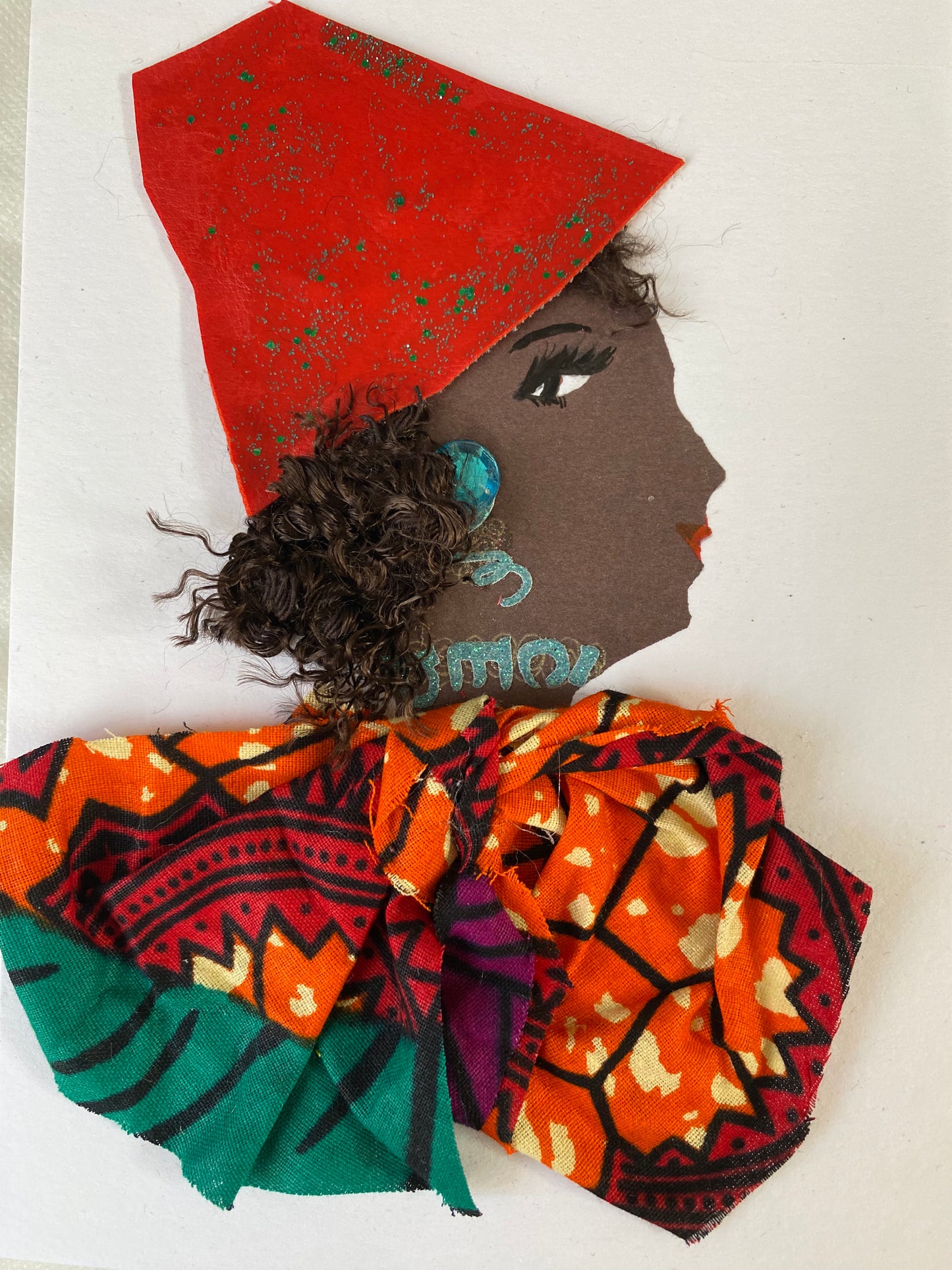 I designed this card of a black woman who is wearing a divine bright red hat with green sparkles. She wears an elegant ankara print blouse. She wears sparkly blue jewellery.  