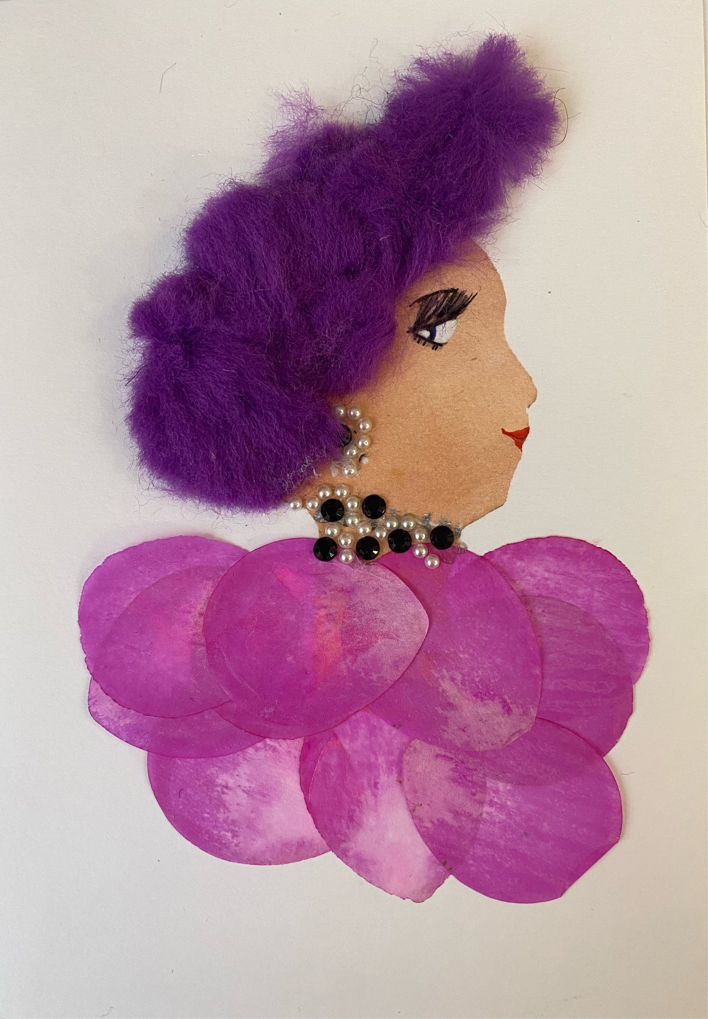 I designed this card of a woman called Rosie Pink. She has a white skin tone and wears a fluffy purple hatinator. She wears a pink flower petal blouse and wears black and pearl jewellery.  
