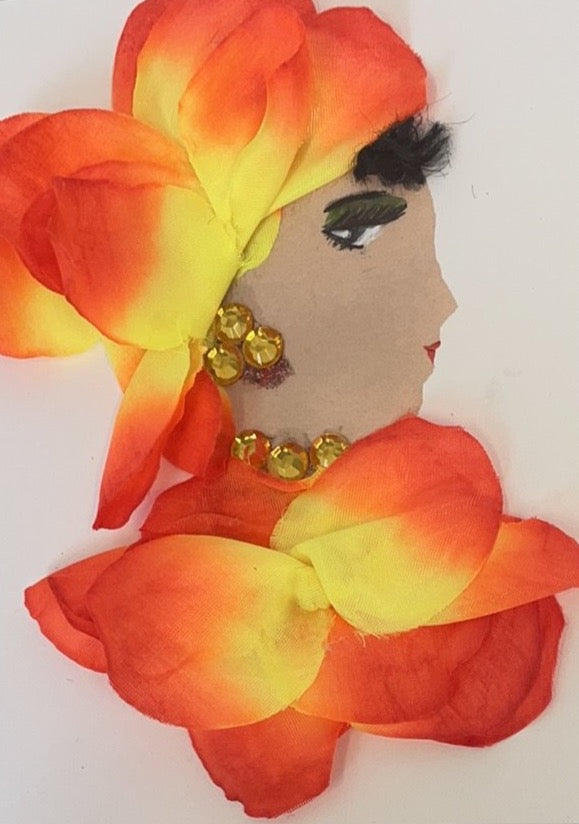 This card is called Olivia. She wears bright orange/yellow flower petals as her headdress and blouse. 