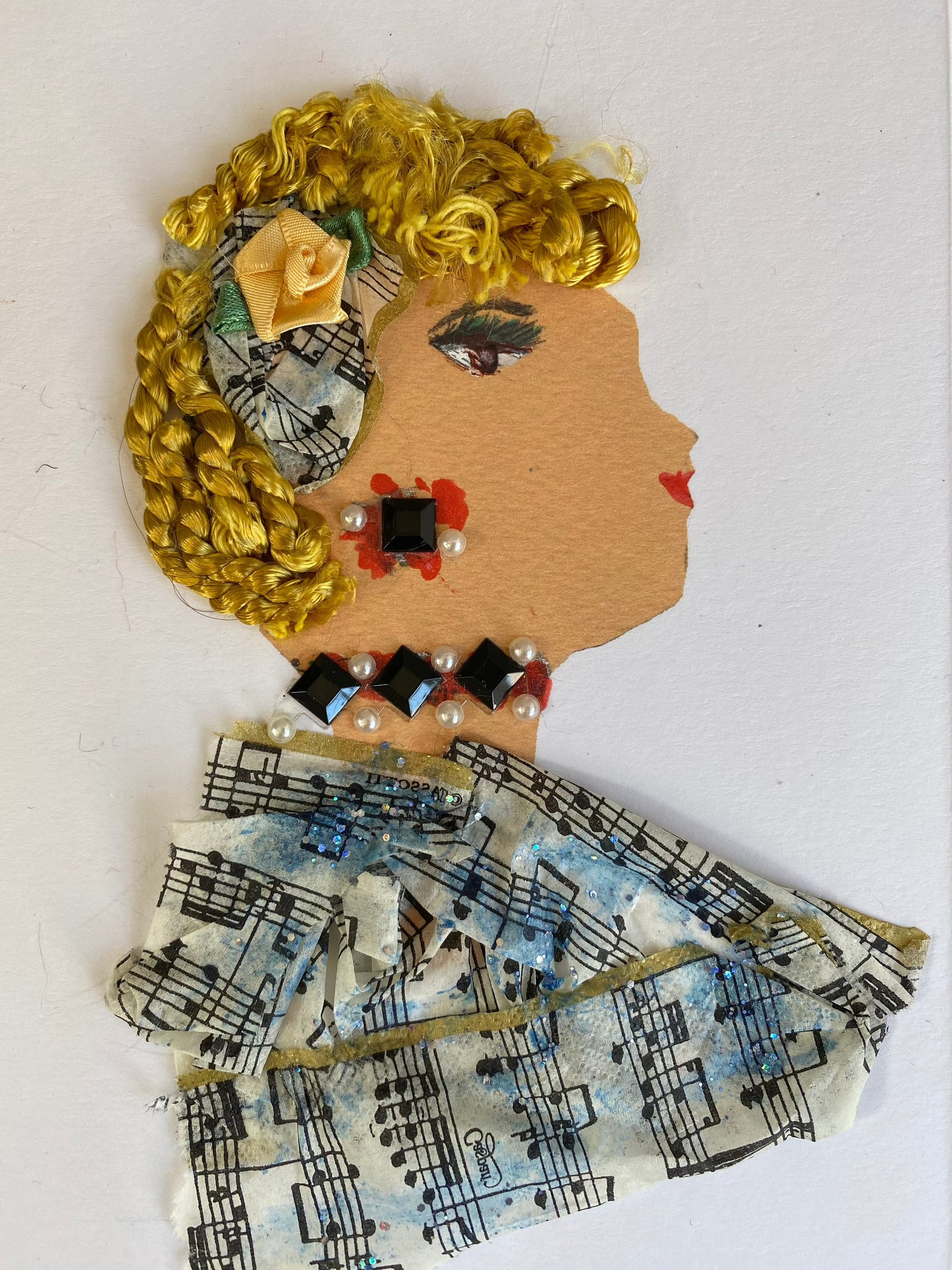 I designed this card of a woman named Musical Melody. She has a white skin tone and is wearing a small music note print hat in her hair. On top of the hat there is a peach colour flower. She wears a music print blouse. She wears black, red, and pearl gem jewellery.