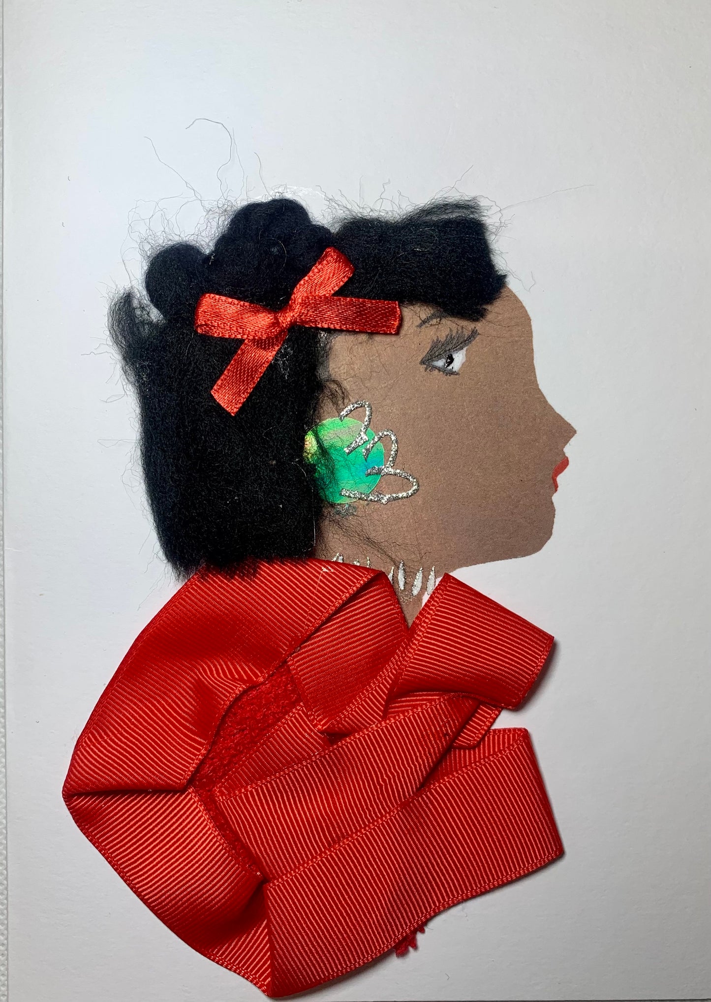 I designed this card of a woman who is named is Totteridge Tilly. She has a brown skin tone and wears a red ribbon blouse with a small red satin bow in her short black hair. She wears beautiful green and silver earrings with a silver necklace.